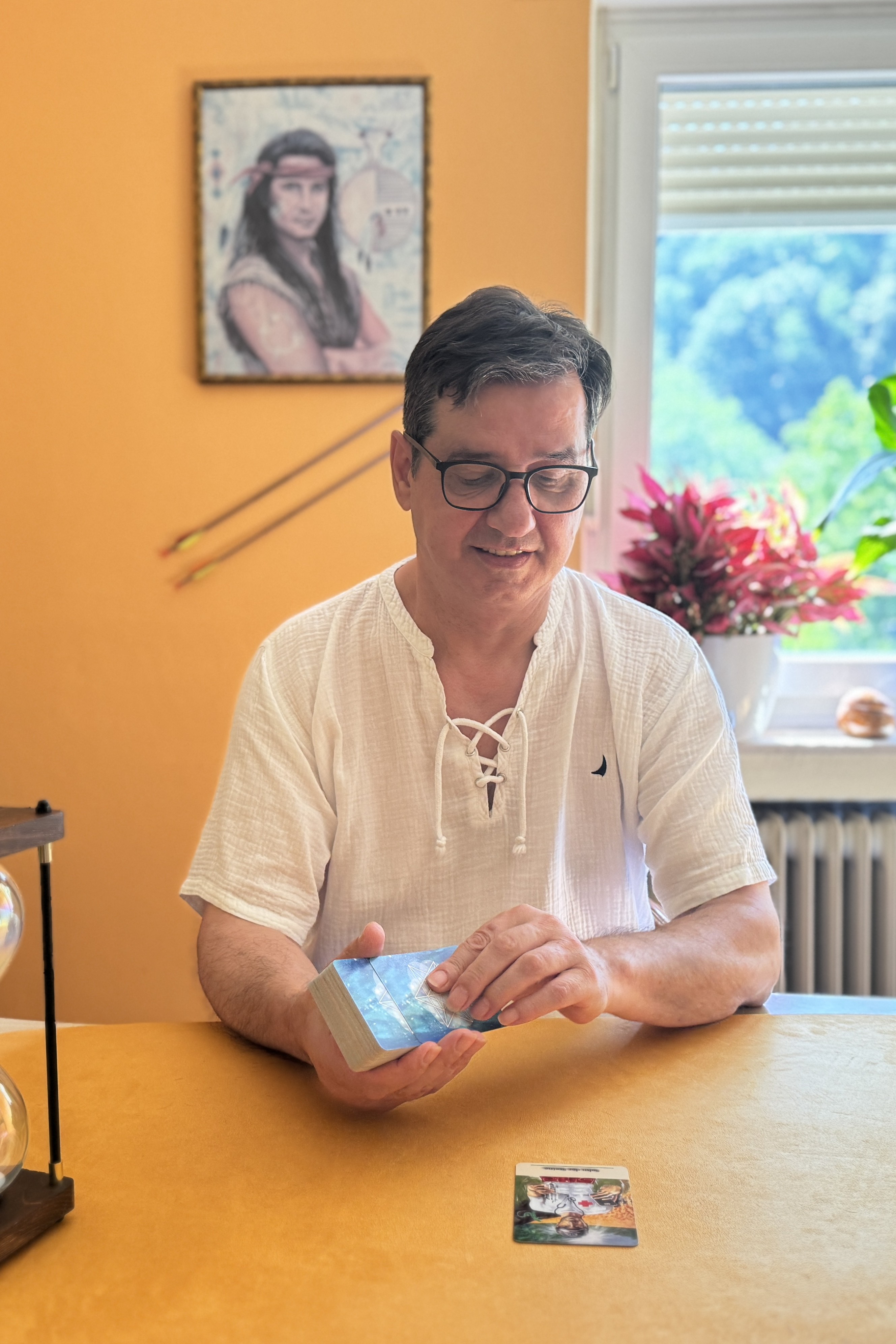 Sakis mischt die SAKIS-TAROT-Karten an seinem Beratungstisch